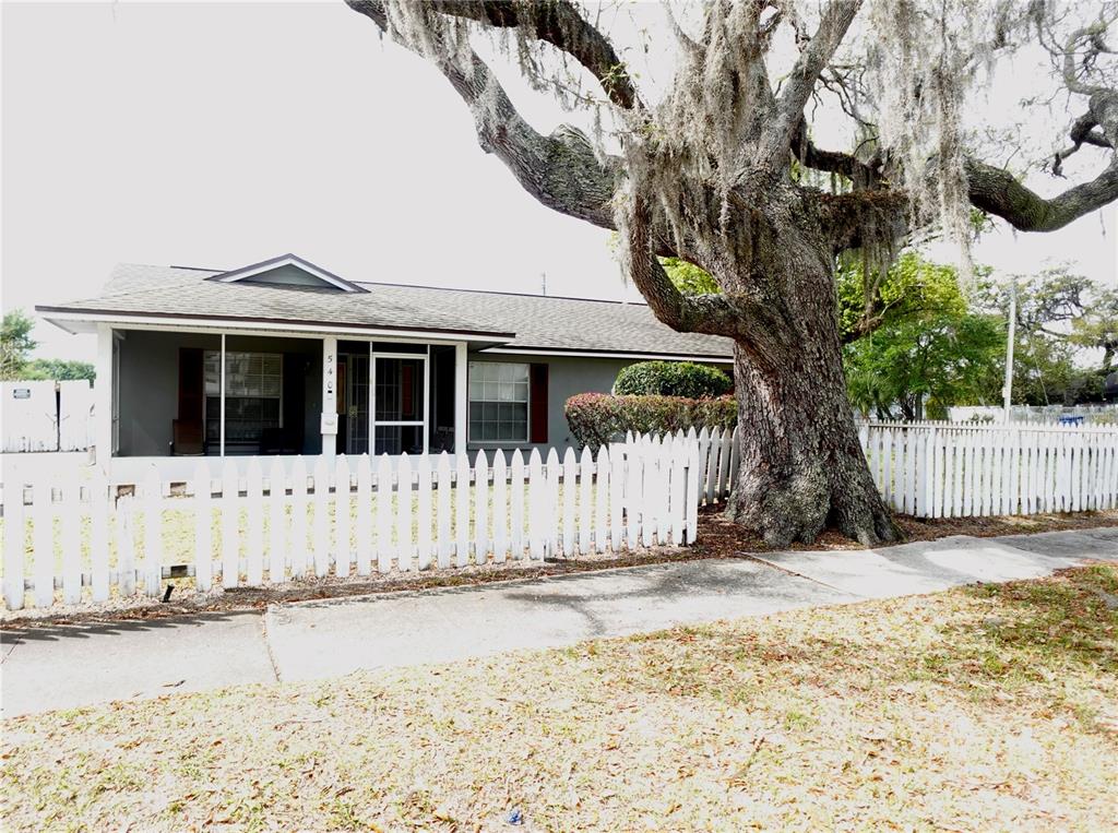 A single-story house with a white picket fence and a large tree in the yard — 540 W COMSTOCK AVENUE, WINTER PARK, FL