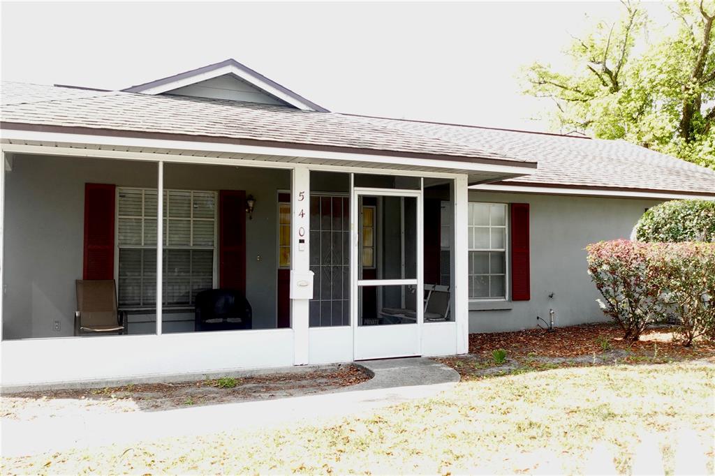A single-story house features a screened-in front porch with red shutters and a concrete walkway — 540 W COMSTOCK AVENUE, WINTER PARK, FL