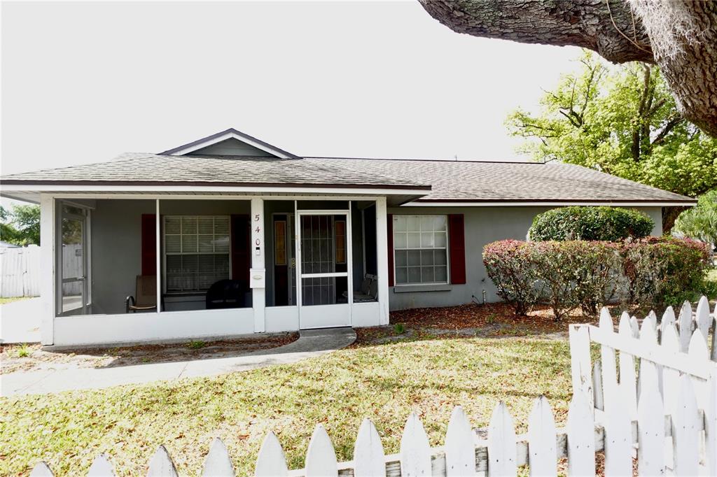 A single-story house with a screened-in front porch and a white picket fence — 540 W COMSTOCK AVENUE, WINTER PARK, FL