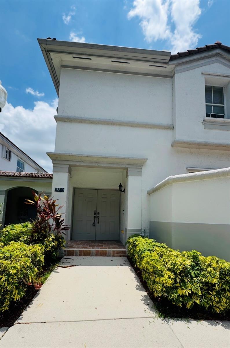 A two-story white stucco house features a double front door and a concrete walkway — 15810 SW 40th St # 57, Miramar FL 33027, MIRAMAR, FL