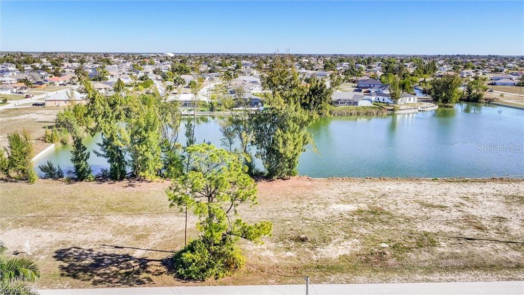 An elevated view of a vacant lot bordering a lake in a residential neighborhood — 1235 NW 20TH PLACE, CAPE CORAL, FL