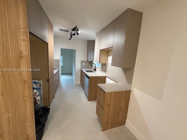 A modern kitchen features wood-grain cabinetry, light countertops, and a black faucet — 328 NE 57th St, Miami FL 33137, MIAMI, FL