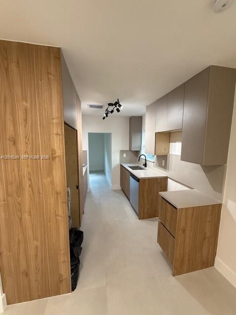 A modern kitchen features wood-grain cabinetry, light countertops, and a narrow layout with tiled flooring — 328 NE 57th St, Miami FL 33137, MIAMI, FL