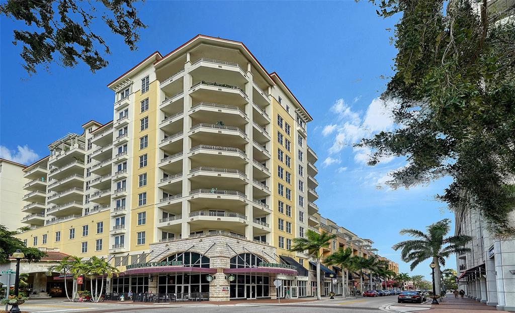 A multi-story yellow apartment building features a ground-level Starbucks and wrap-around balconies — 100 CENTRAL AVENUE UNIT K817, SARASOTA, FL