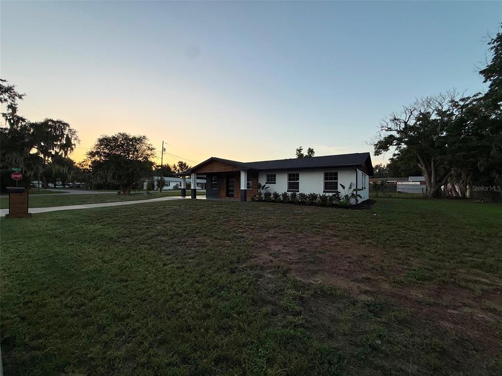 A single-story house with a white exterior and a covered porch sits on a lawn — 1301 NICHOLS DRIVE, TAVARES, FL