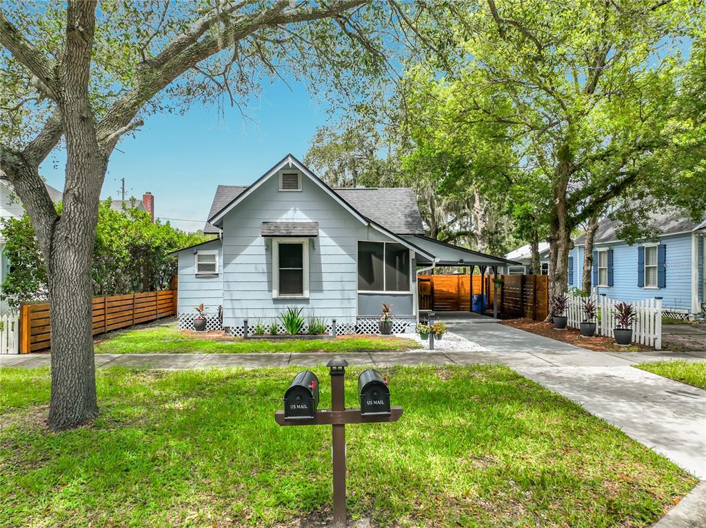 A light blue single-story house with a carport, front lawn, and two mailboxes on posts — 306 S ELM AVENUE, SANFORD, FL