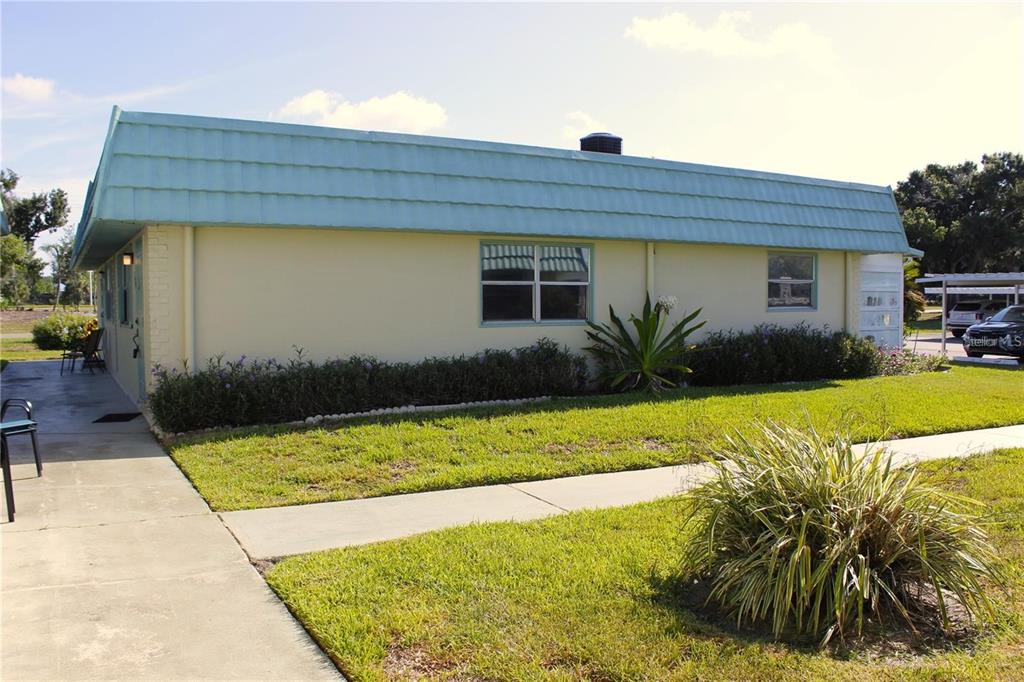 A single-story house with a light blue mansard roof and cream-colored exterior walls — 101 CAMBRIDGE TRAIL UNIT 194, SUN CITY CENTER, FL
