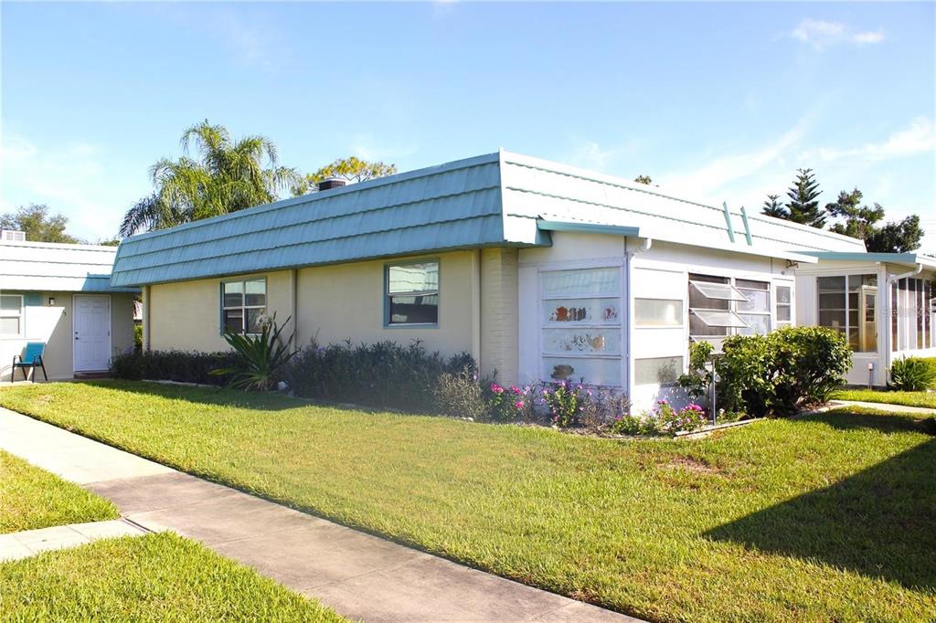 A low-slung, light-colored house with a blue mansard roof and a small front lawn — 101 CAMBRIDGE TRAIL UNIT 194, SUN CITY CENTER, FL