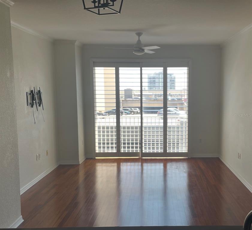 An empty living room features hardwood floors, a ceiling fan, and sliding glass balcony doors — 700 S HARBOUR ISLAND BOULEVARD UNIT 536, TAMPA, FL