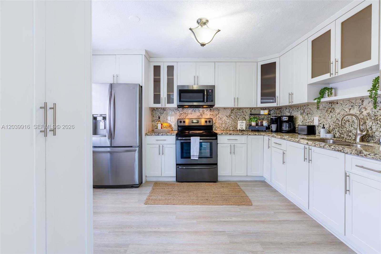 A kitchen features white cabinets, stainless steel appliances, and granite countertops — 6801 Park St # 6801, Hollywood FL 33024, HOLLYWOOD, FL