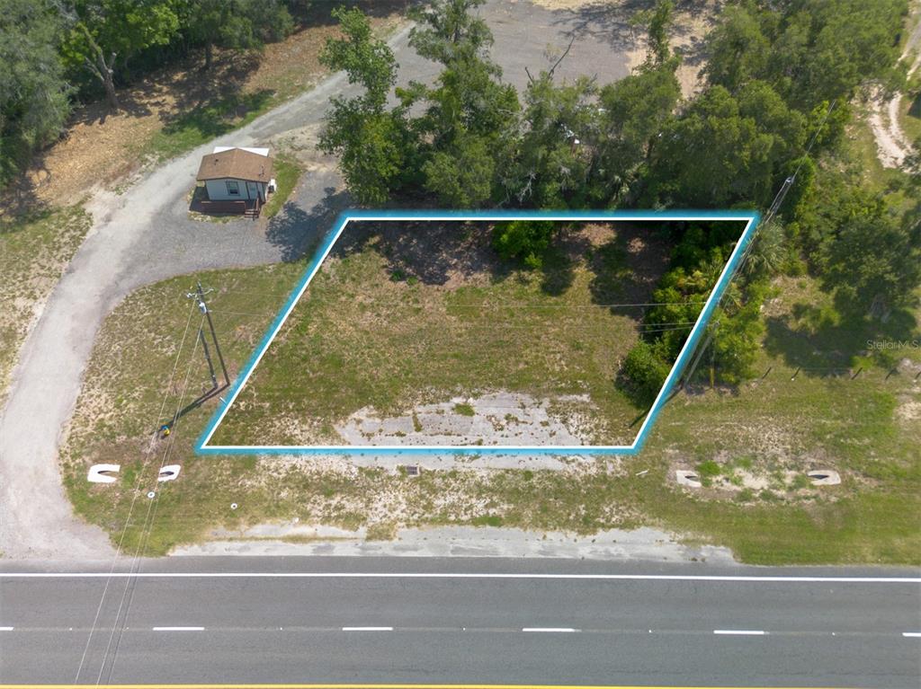 An aerial view shows a vacant, rectangular lot outlined in blue next to a road — 4457 N US HIGHWAY 17, DELAND, FL