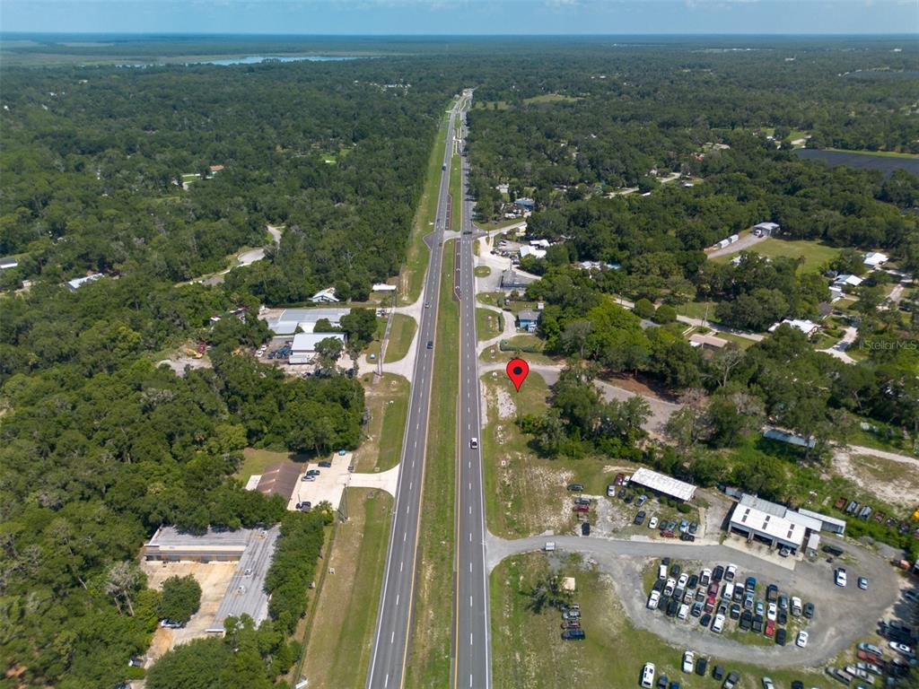 An aerial view shows a vacant lot marked with a pin beside a divided highway — 4457 N US HIGHWAY 17, DELAND, FL