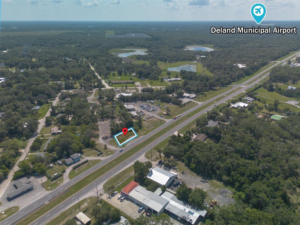 An aerial view shows a vacant, rectangular lot outlined in blue along a highway — 4457 N US HIGHWAY 17, DELAND, FL
