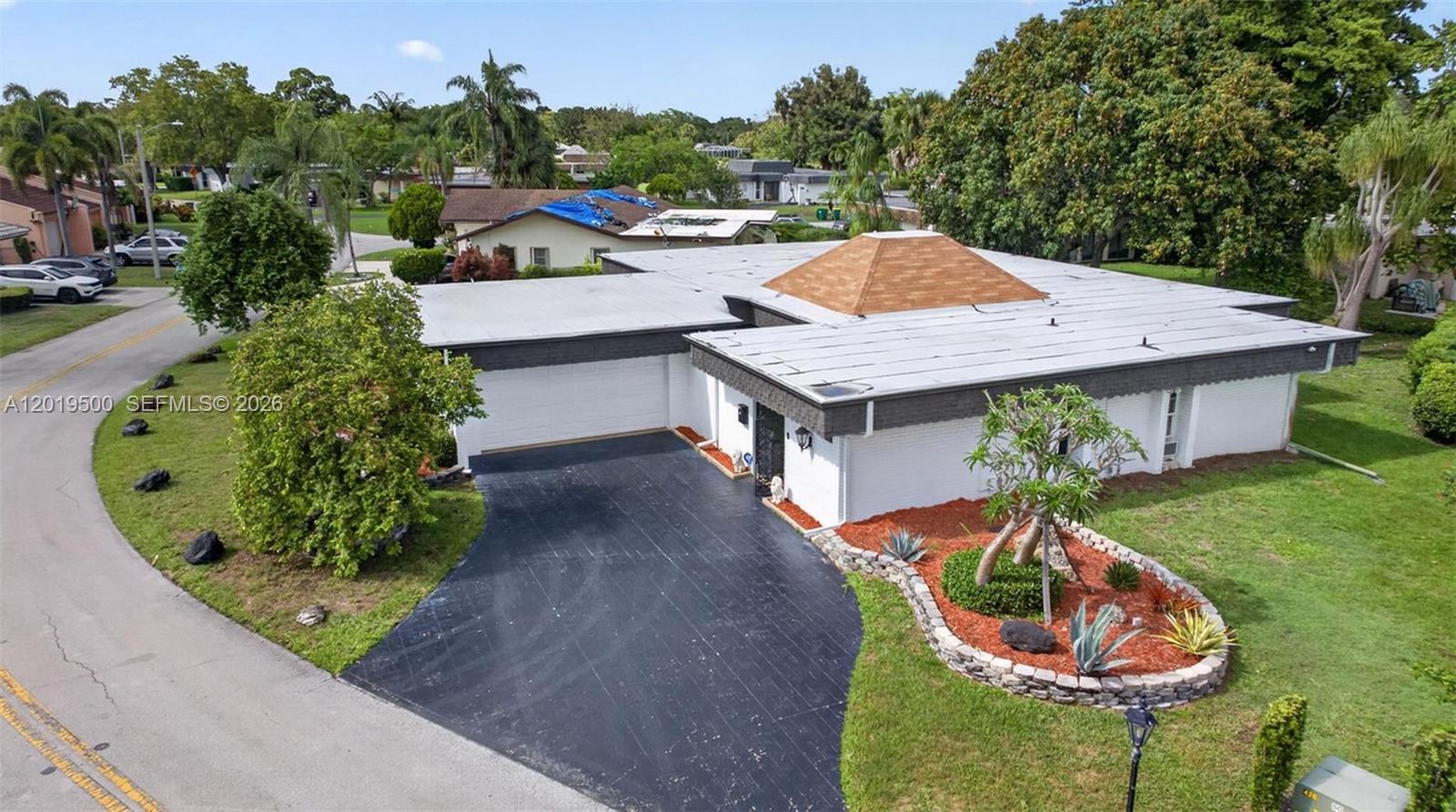 An aerial view shows a single-story house with a flat roof, a central pyramid feature, and a driveway — 4806 Banyan Ln, Tamarac FL 33319, TAMARAC, FL