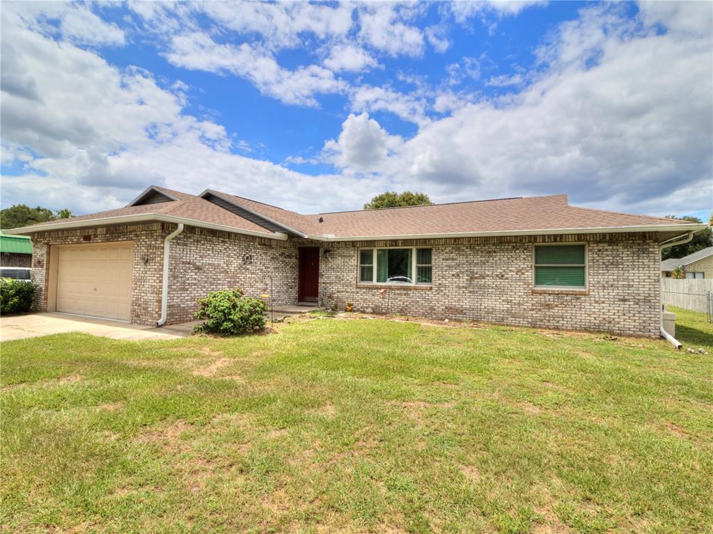 A single-story brick house with a tan garage and a brown shingled roof — 3815 SE 62ND STREET, OCALA, FL