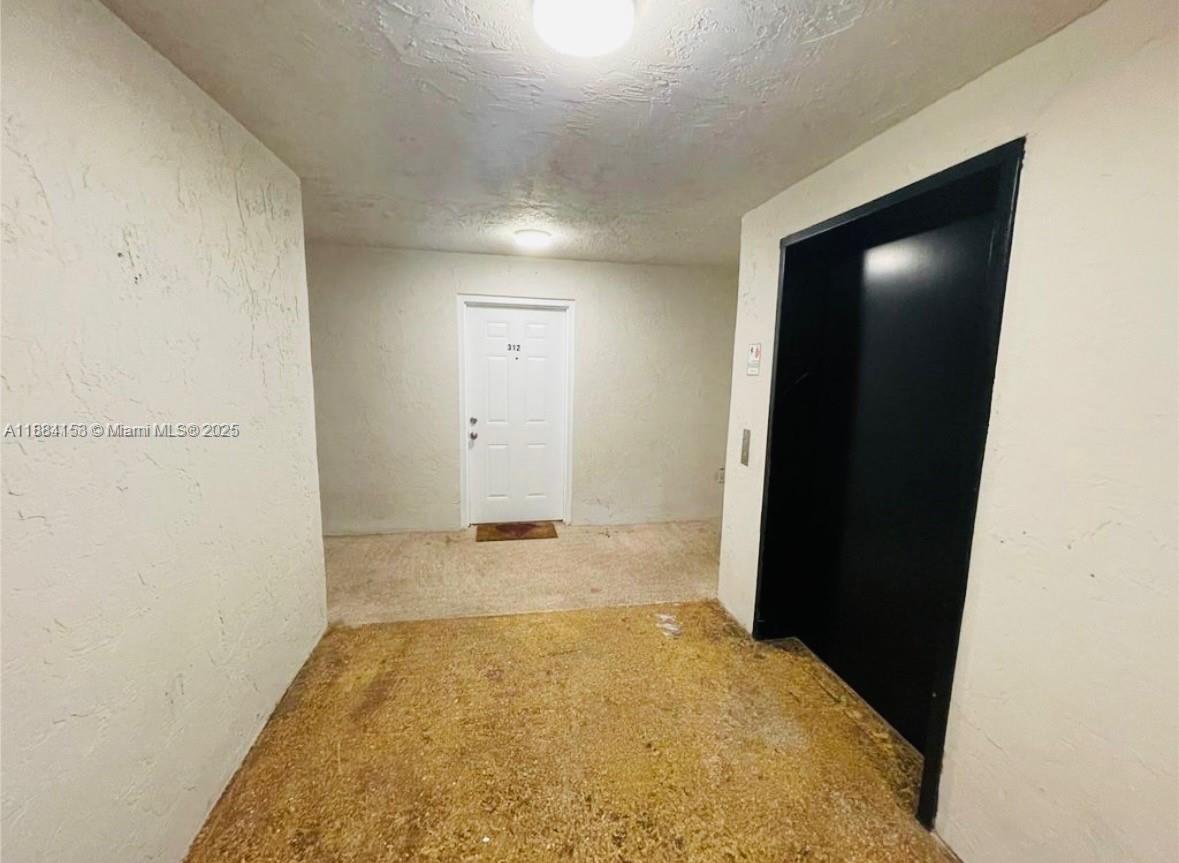 A hallway features a white door labeled 312 next to a black elevator door — 16220 NW 2nd Ave # 213, Miami FL 33169, MIAMI, FL