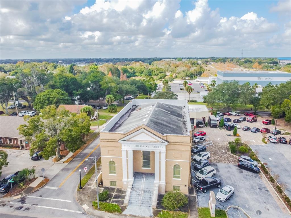 An aerial view shows a tan brick church building with a parking lot and trees — 541 S FLORIDA AVENUE, LAKELAND, FL