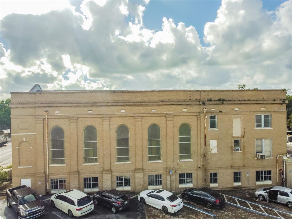 An exterior view of a multi-story brick building with arched windows and a parking lot — 541 S FLORIDA AVENUE, LAKELAND, FL