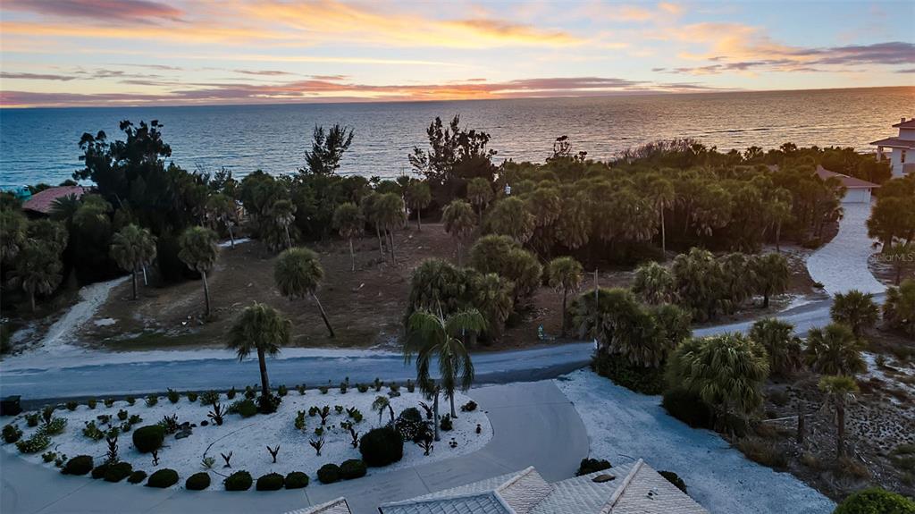 An elevated view of a coastal property featuring palm trees, a driveway, and ocean views — N MANASOTA KEY ROAD, ENGLEWOOD, FL