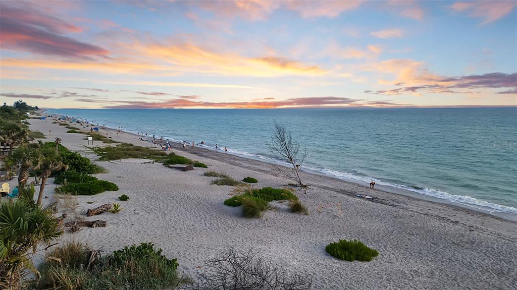 An elevated view of a sandy beach at sunset with ocean waves and coastal vegetation — N MANASOTA KEY ROAD, ENGLEWOOD, FL