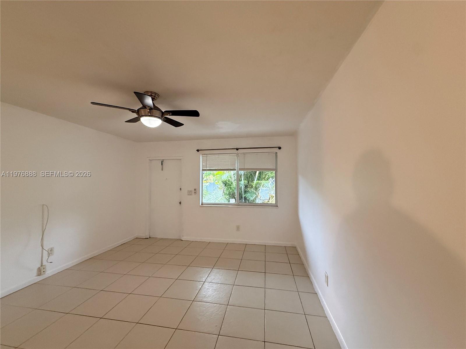 A room with white walls, light-colored tile flooring, a ceiling fan, and a single window — 1104 N 17th Ct # 105, Hollywood FL 33020, HOLLYWOOD, FL