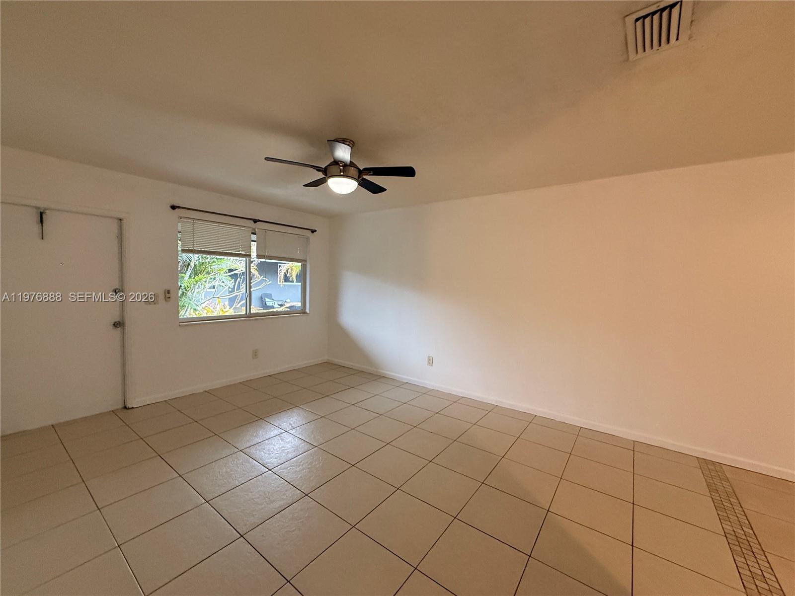 A room with white walls, beige tile flooring, a ceiling fan, and a window — 1104 N 17th Ct # 105, Hollywood FL 33020, HOLLYWOOD, FL
