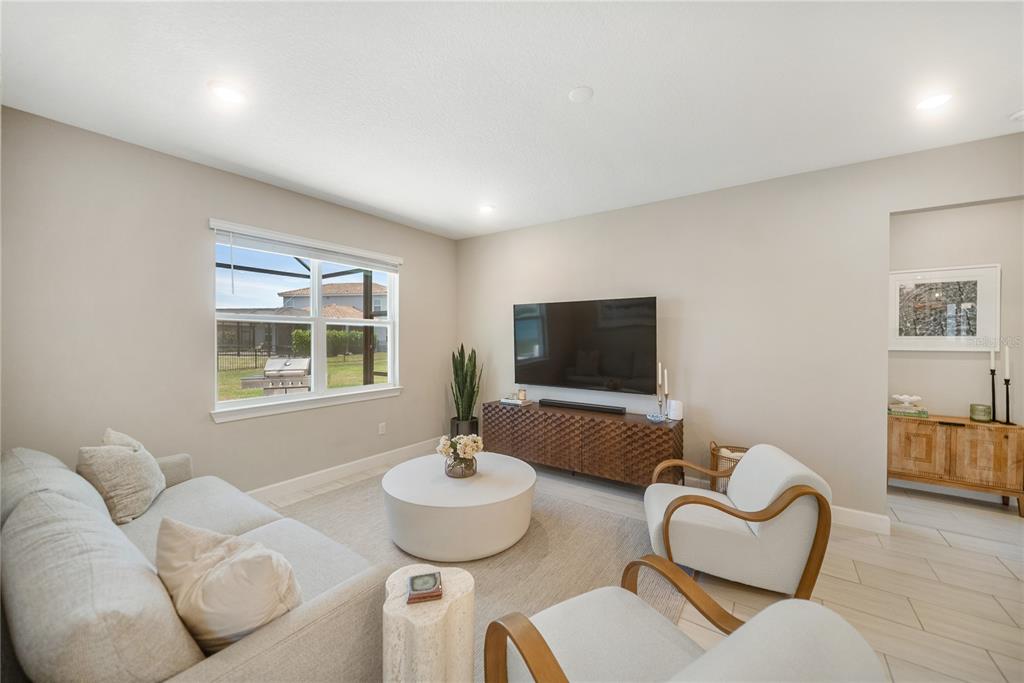 A living room features a sofa, two armchairs, a coffee table, and a wall-mounted television — 3312 BIG SKY WAY, BRADENTON, FL