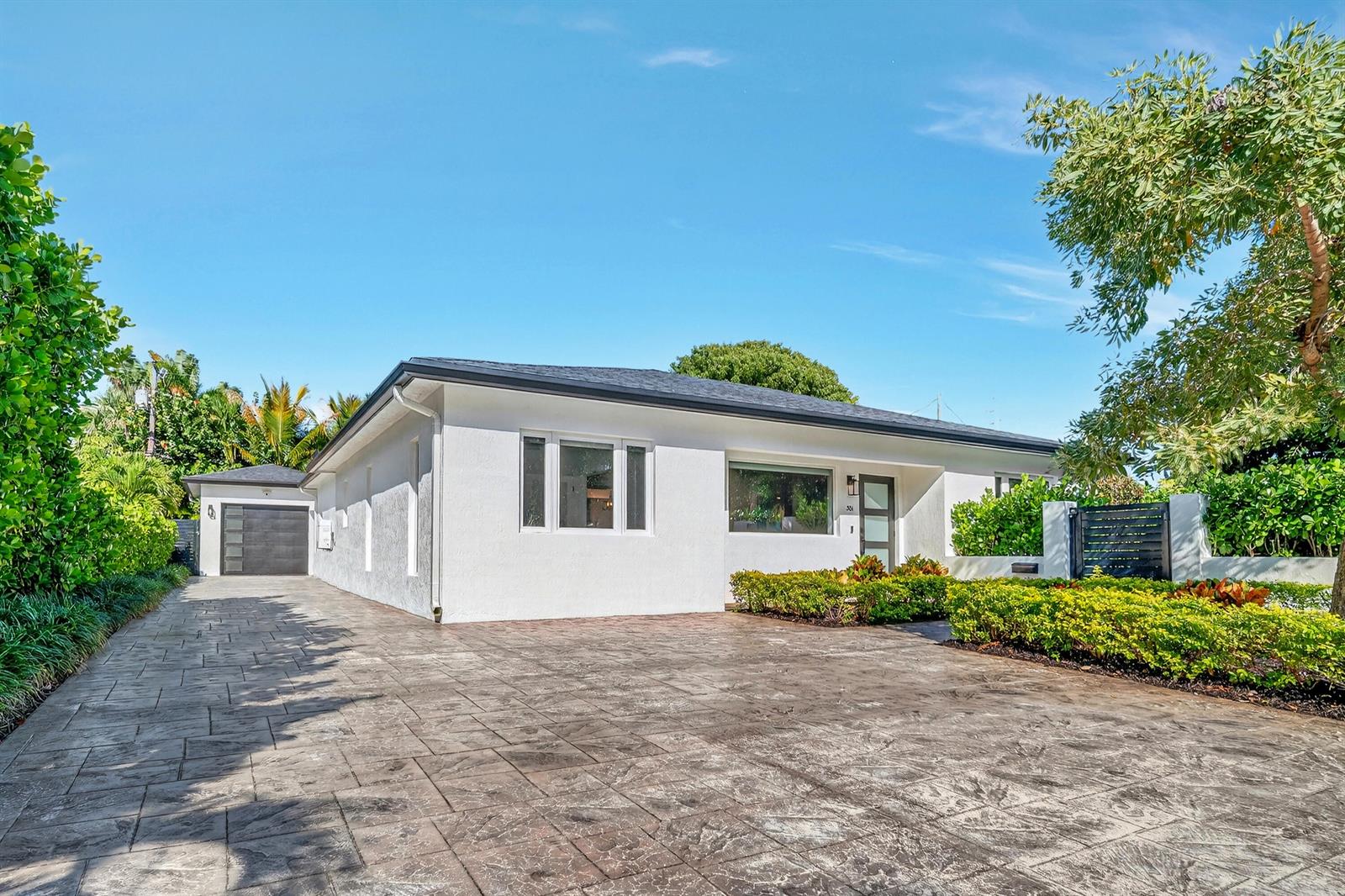 A white single-story house with a stamped concrete driveway and a detached garage — 301 Pilgrim Road, West Palm Beach FL 33405, WEST PALM BEACH, FL
