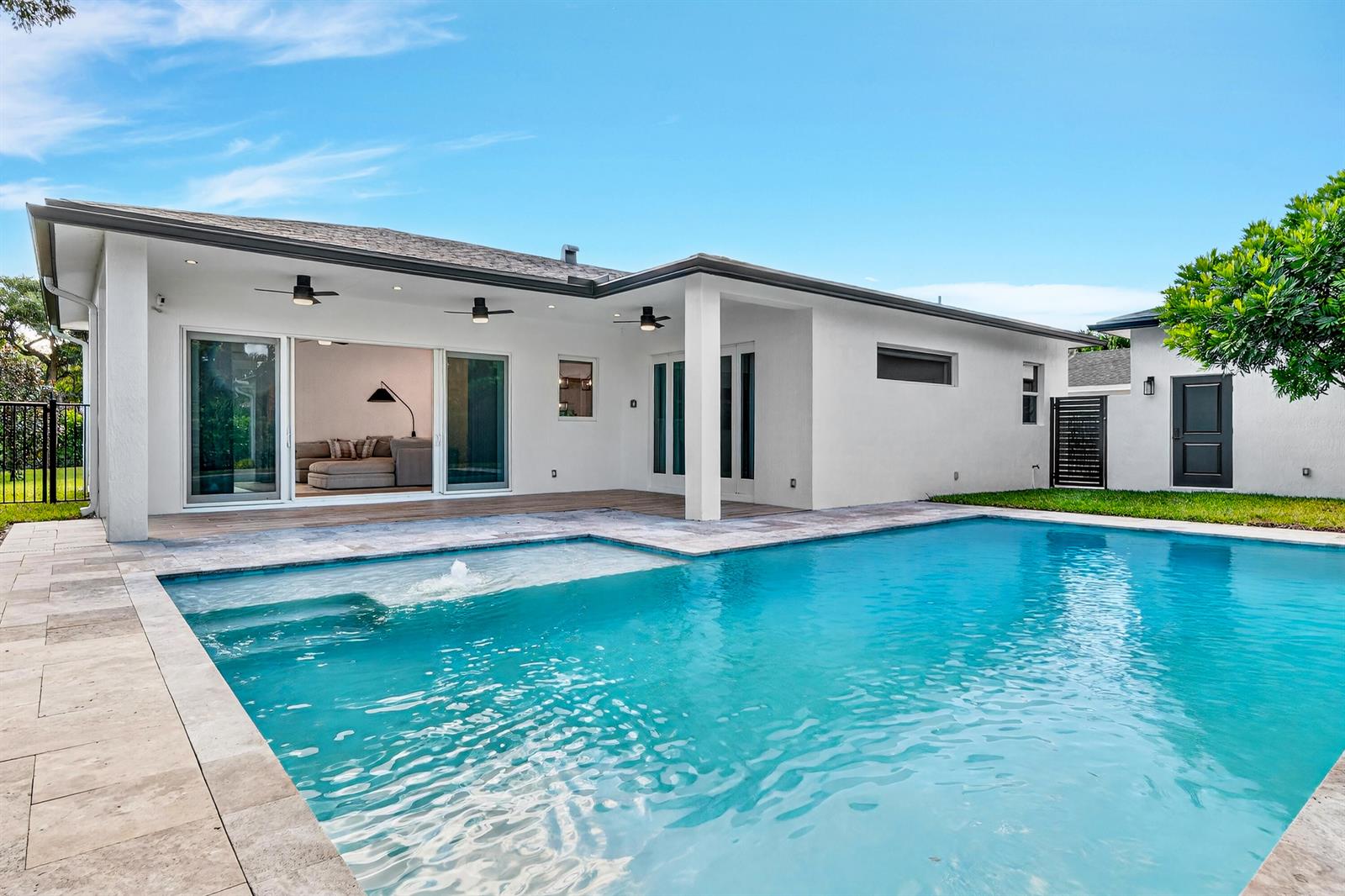 A white house with a swimming pool, patio, and sliding glass doors under a blue sky — 301 Pilgrim Road, West Palm Beach FL 33405, WEST PALM BEACH, FL