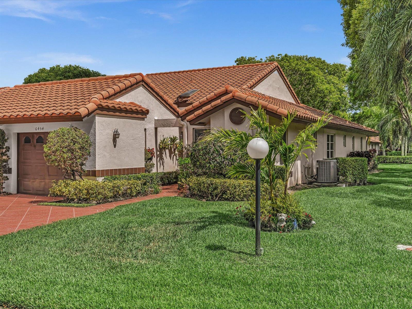 A single-story house with a brown tile roof, stucco exterior, and a green lawn — 6454 Pointe Pleasant Circle, Delray Beach FL 33484, DELRAY BEACH, FL