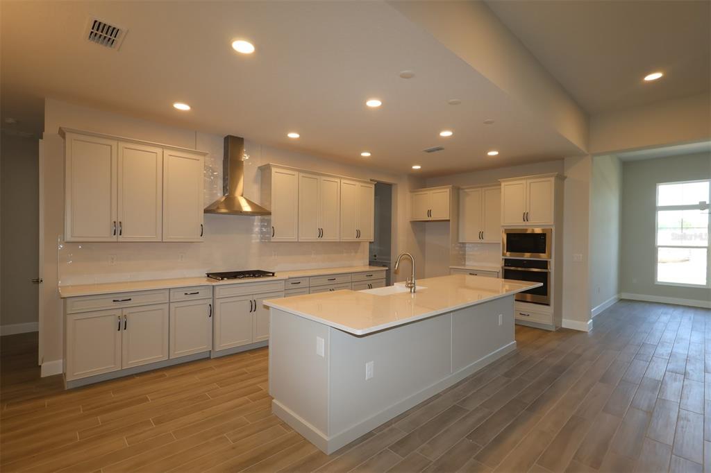 A single-story house with a stone-accented facade, a paved driveway, and a two-car garage — 3177 WOLF LAKE AVENUE, APOPKA, FL
