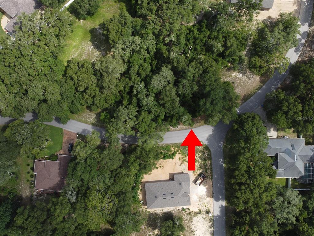 An aerial view shows a house under construction on a wooded lot near a road — 5078 WESTLAKE BOULEVARD, DADE CITY, FL