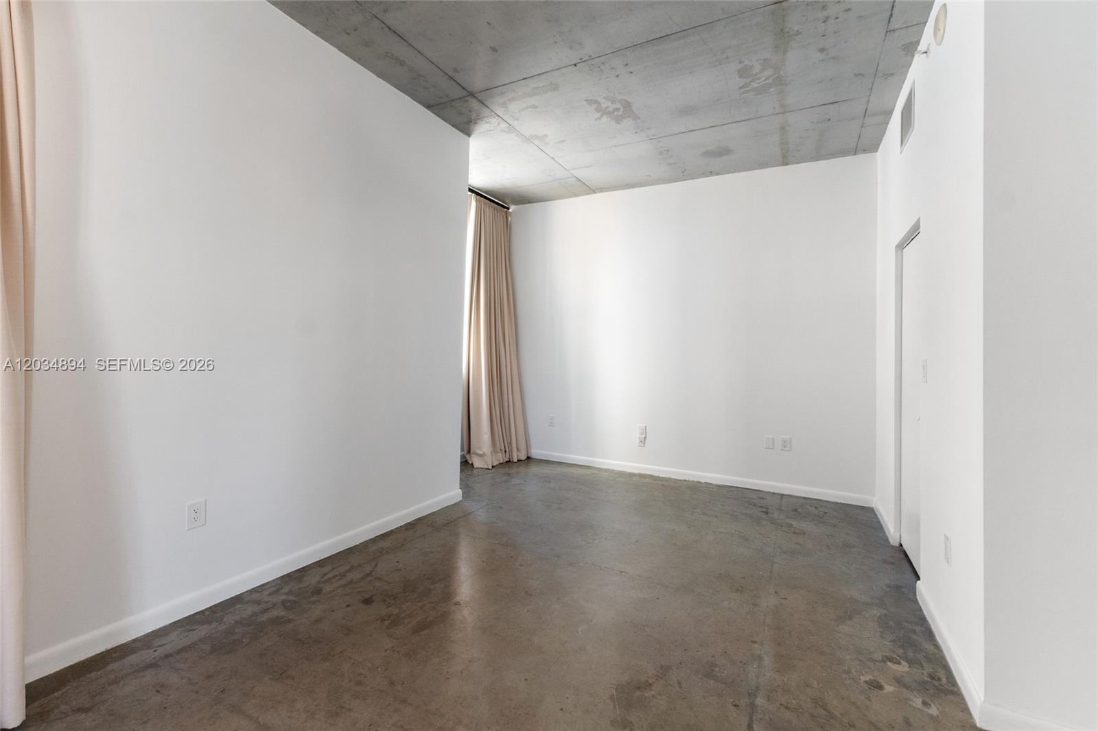 An empty room features white walls, a concrete ceiling, and a polished concrete floor — 133 NE 2nd Ave # 801, Miami FL 33132, MIAMI, FL