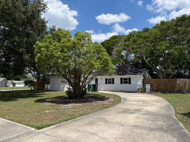 A single-story white house with a concrete driveway and a large tree in the yard — 1092 EASTBROOK BOULEVARD, WINTER PARK, FL