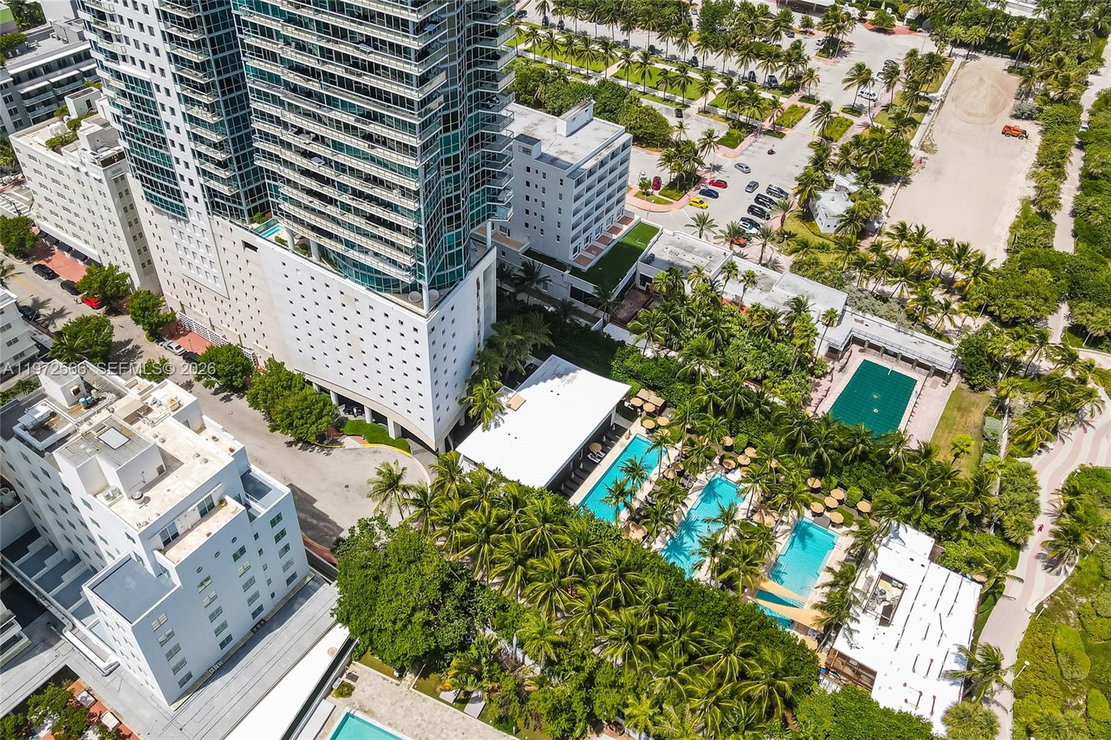 An aerial view shows a high-rise building, multiple swimming pools, and surrounding palm trees — 101 20th St # 3806, Miami Beach FL 33139, MIAMI BEACH, FL