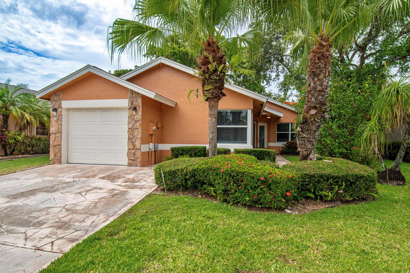 A single-story house with a peach stucco exterior, stone accents, and a paved driveway — 7601 Martinique Boulevard, Boca Raton FL 33433, BOCA RATON, FL