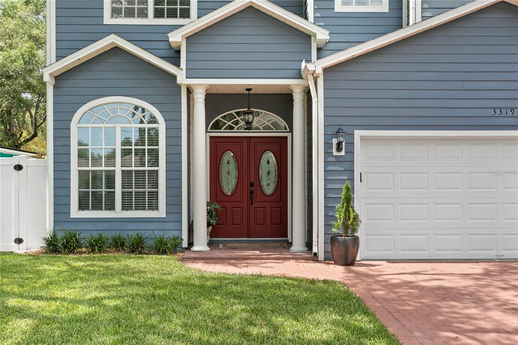 The exterior of a blue house features a red double front door and a garage — 3319 W VILLA ROSA STREET, TAMPA, FL