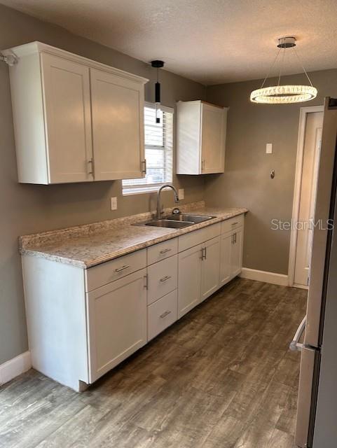 A kitchen features white cabinets, a light-colored countertop, and a modern circular light fixture — 1135 SIBONEY STREET NW, PALM BAY, FL