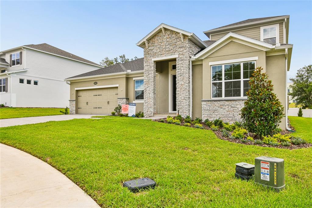 A single-story house with a stone-accented entryway, a two-car garage, and a manicured lawn — 3326 WOLF LAKE AVENUE, APOPKA, FL