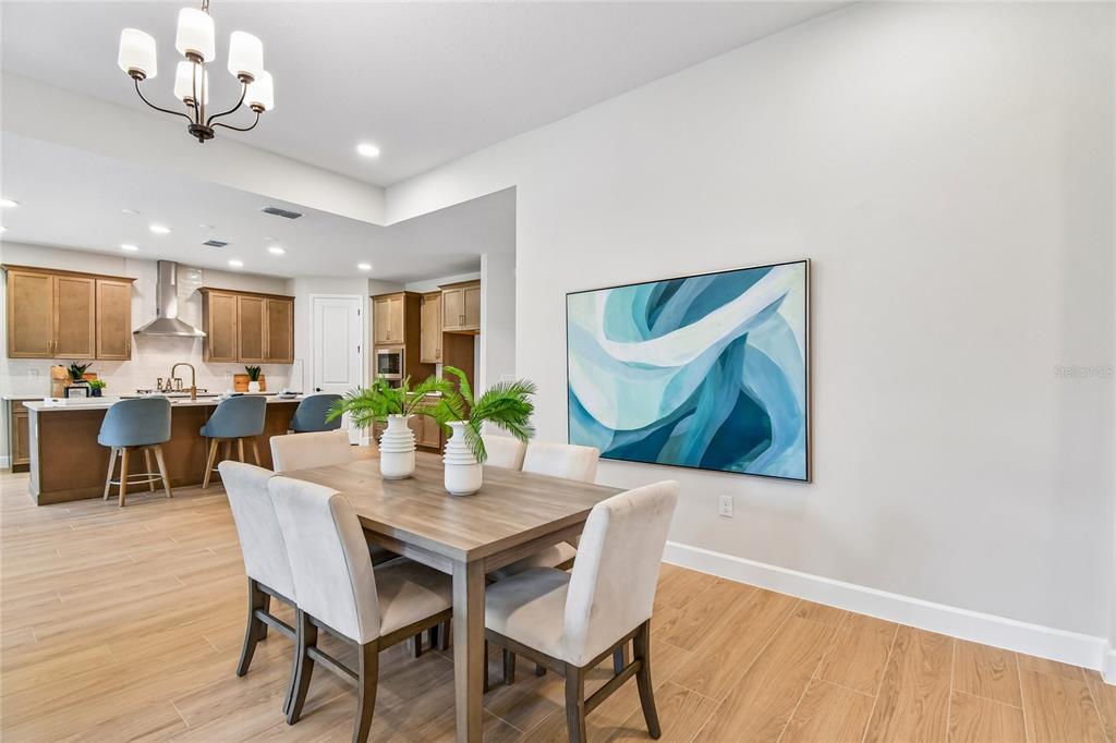 A dining area with a wooden table and chairs sits adjacent to an open kitchen — 3326 WOLF LAKE AVENUE, APOPKA, FL
