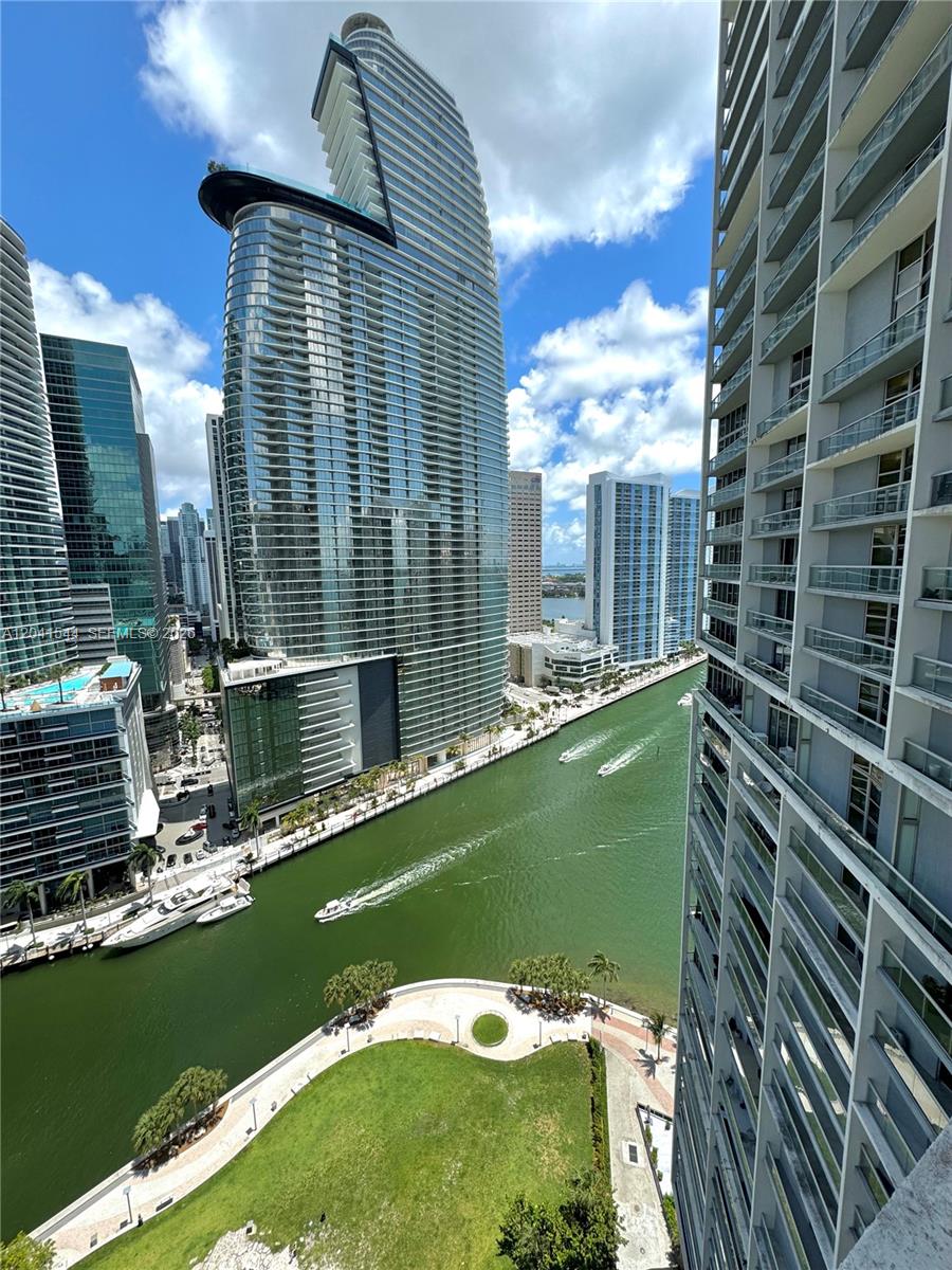 An elevated view of a canal, boats, and modern high-rise buildings in a city — 475 Brickell Ave # 2512, Miami FL 33131, MIAMI, FL