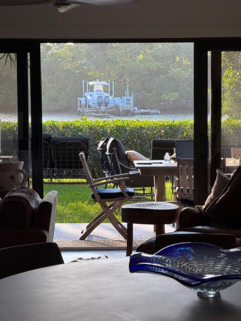 A view from inside a room looking out through sliding glass doors to a backyard boat — 3605 S Ocean Boulevard, South Palm Beach FL 33480, SOUTH PALM BEACH, FL