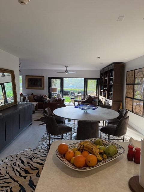 A dining area with a round table and chairs opens to a living room and patio — 3605 S Ocean Boulevard, South Palm Beach FL 33480, SOUTH PALM BEACH, FL