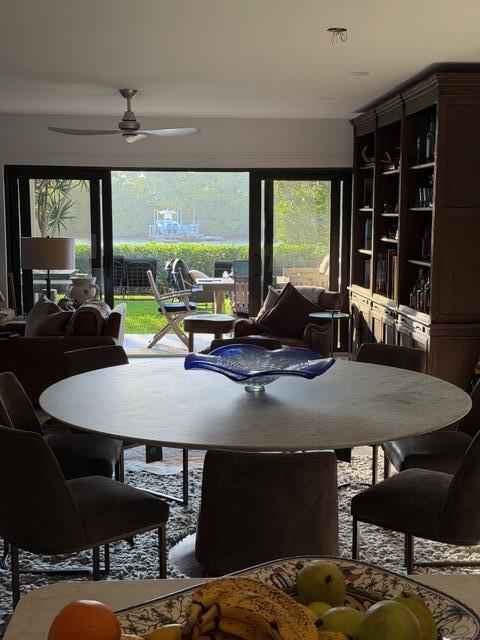 A dining room with a round table overlooks a patio and a waterway with a boat — 3605 S Ocean Boulevard, South Palm Beach FL 33480, SOUTH PALM BEACH, FL