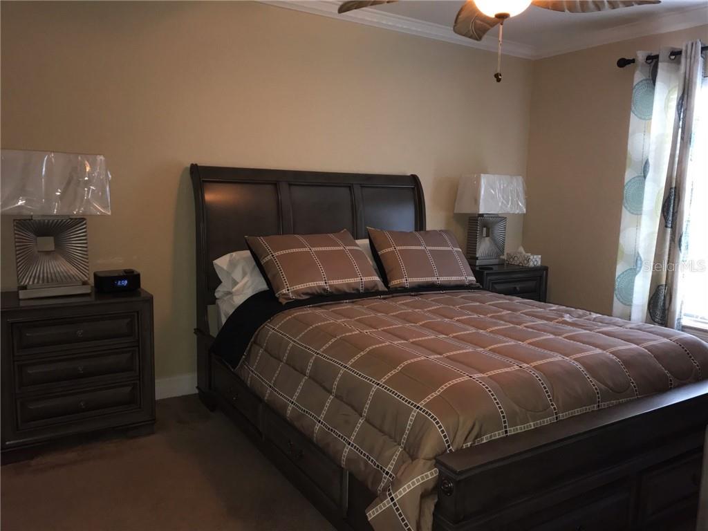 A bedroom features a dark wood sleigh bed, matching nightstands, and patterned curtains — 1211 SAXONY CIRCLE UNIT A-1, PUNTA GORDA, FL