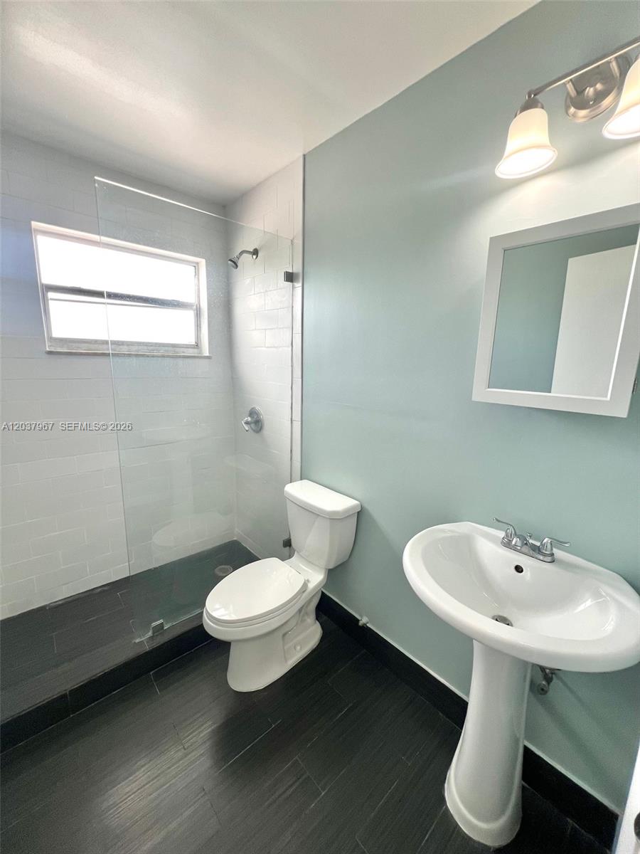A bathroom features a pedestal sink, a toilet, and a glass-enclosed walk-in shower — 685 NE 85th St # 9, Miami FL 33138, MIAMI, FL