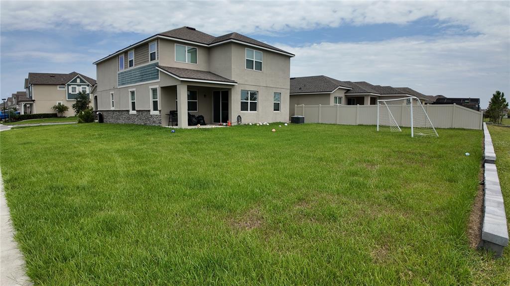 A two-story house with a large backyard, a patio, and a soccer goal — 2436 BLOWING BREEZE AVENUE, KISSIMMEE, FL