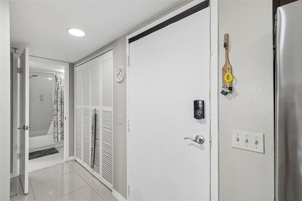 A white door with a digital lock stands next to a closet and a bathroom — 5915 SEA RANCH DRIVE UNIT 611, HUDSON, FL