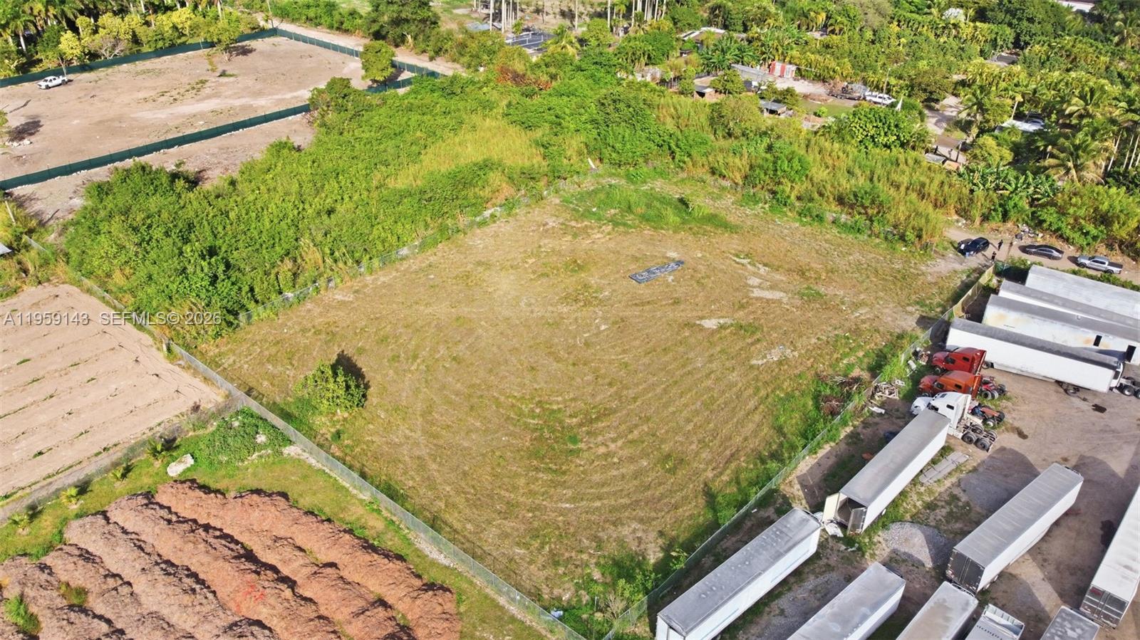 An aerial view shows a fenced, rectangular vacant lot surrounded by vegetation and trailers — 160XX SW 207TH AVE, Miami FL 33187, MIAMI, FL