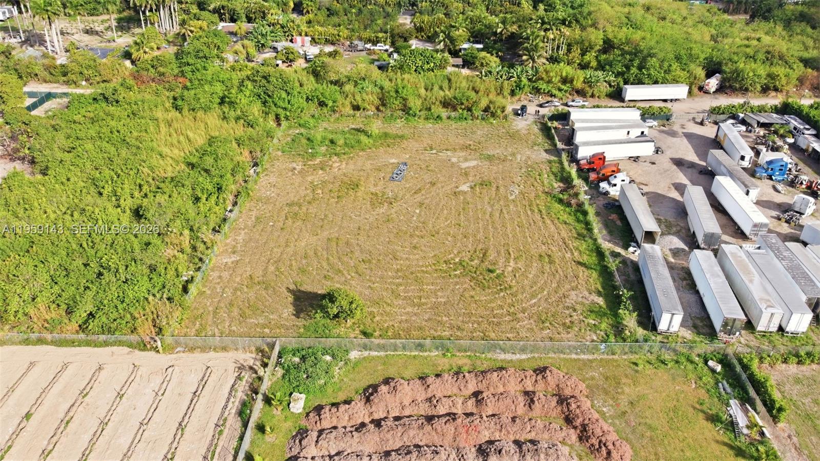 An aerial view shows a rectangular vacant lot bordered by dense vegetation and parked trailers — 160XX SW 207TH AVE, Miami FL 33187, MIAMI, FL